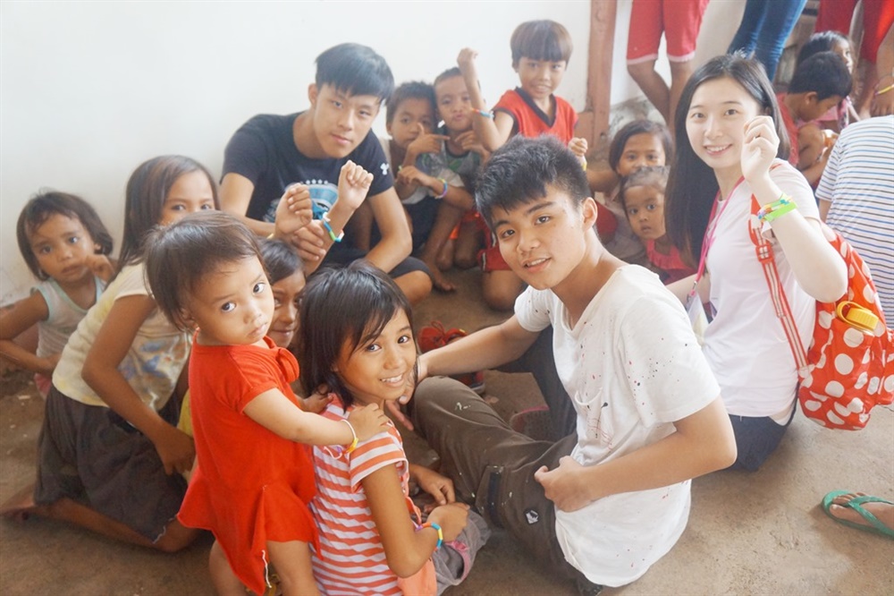 喜歡接觸人群、挑戰自我的賴柏瑞（前排右一），高二時到菲律賓擔任志工，照顧孤兒院的孩童。（照片提供／賴柏瑞）
