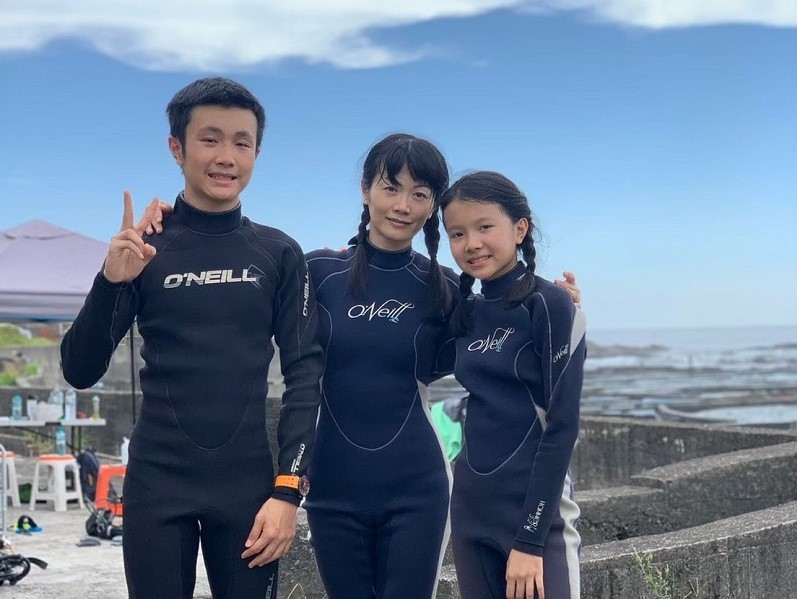 何桂禎（中）跟孩子出國旅行、潛水，從生活中學習英文，並透過英文測驗結果來了解孩子的英文程度。